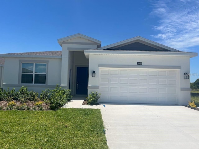 single story home with a garage, a front lawn, driveway, and stucco siding