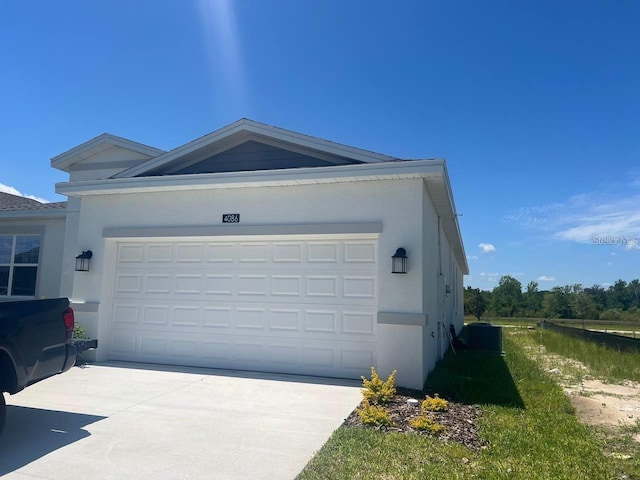 view of home's exterior featuring stucco siding, cooling unit, concrete driveway, and a garage