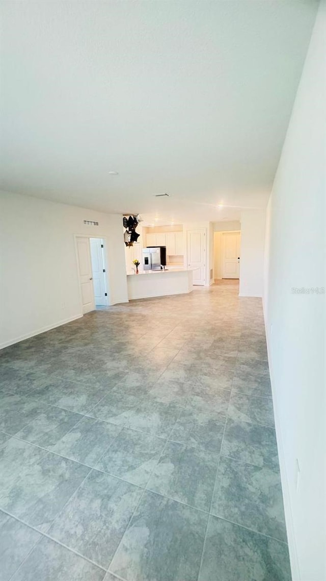 unfurnished living room featuring baseboards