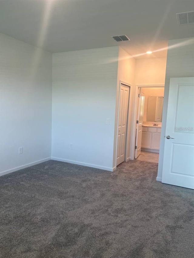 unfurnished room featuring visible vents, baseboards, and carpet