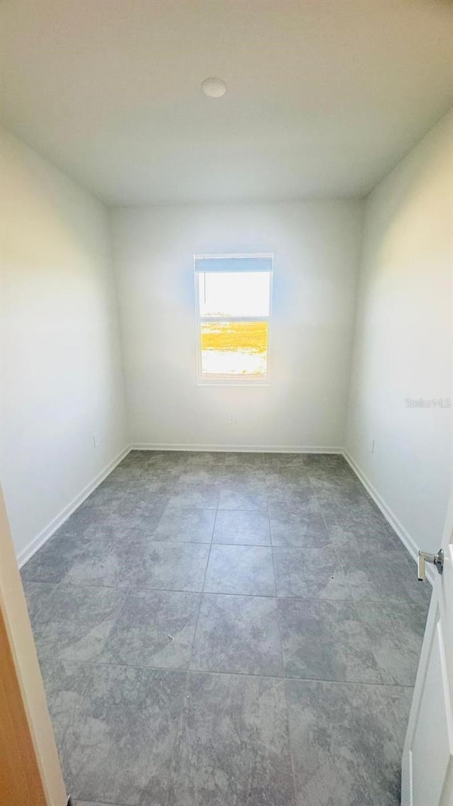 unfurnished room with baseboards