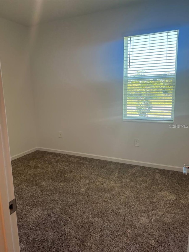 empty room with baseboards and carpet floors