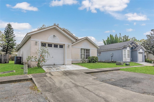 single story home with stucco siding, driveway, central AC, an attached garage, and a front yard