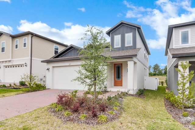 view of front of home with decorative driveway, a garage, board and batten siding, and a front yard