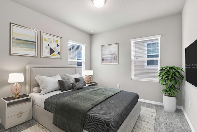 bedroom with light colored carpet and baseboards