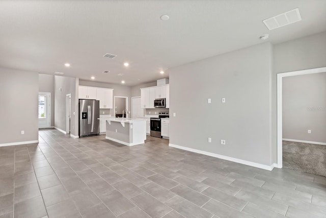 unfurnished living room featuring visible vents, recessed lighting, baseboards, and a sink