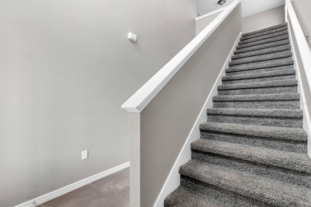 staircase with baseboards and wood finished floors