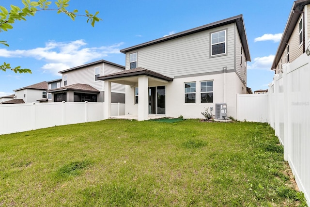 rear view of property with stucco siding, a lawn, central AC unit, and a fenced backyard