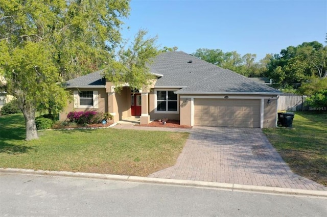 ranch-style house with a front yard, decorative driveway, a garage, and stucco siding