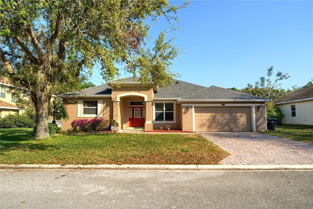 ranch-style home with a front lawn, decorative driveway, a garage, and stucco siding