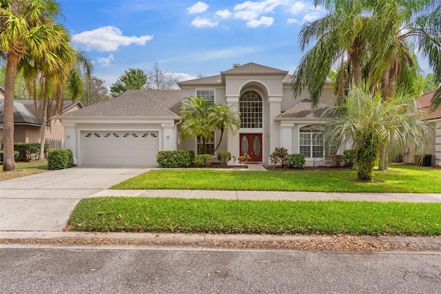 mediterranean / spanish home with stucco siding, driveway, french doors, a front yard, and a garage