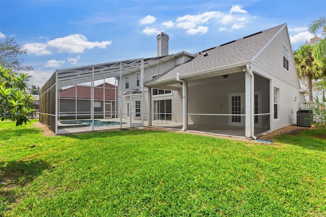 back of property featuring a patio area, a lawn, central AC, and a chimney