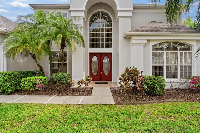 property entrance featuring stucco siding and roof with shingles