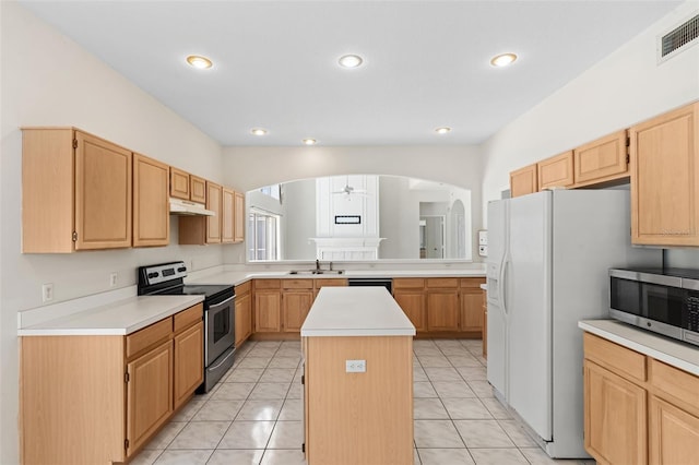 kitchen featuring under cabinet range hood, a sink, a center island, arched walkways, and appliances with stainless steel finishes