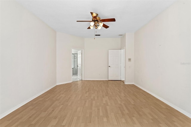 empty room with a ceiling fan, baseboards, visible vents, and light wood finished floors