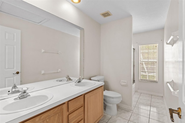 bathroom featuring tile patterned floors, toilet, visible vents, and a sink