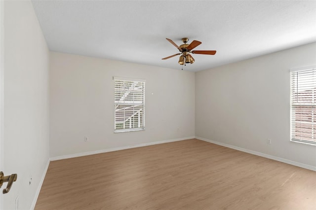 unfurnished room with light wood-style floors, baseboards, and ceiling fan