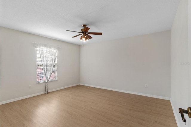 spare room with light wood-style flooring, baseboards, and a ceiling fan