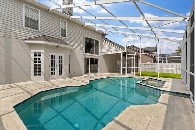 view of swimming pool with a patio, fence, a pool with connected hot tub, french doors, and a lanai