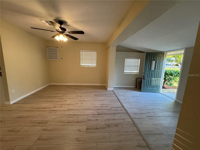 empty room featuring light wood finished floors, visible vents, ceiling fan, and baseboards