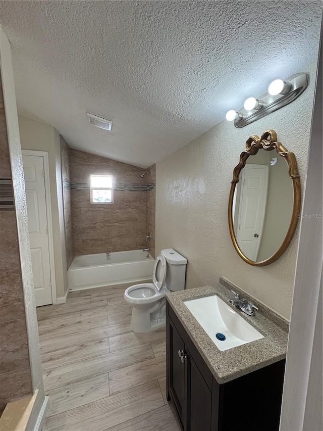 bathroom with visible vents, wood finished floors, a textured wall, a textured ceiling, and washtub / shower combination