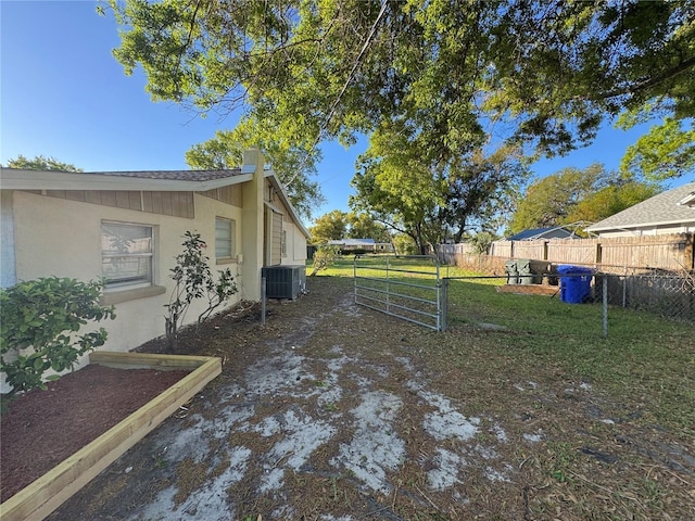 view of yard featuring central air condition unit and fence