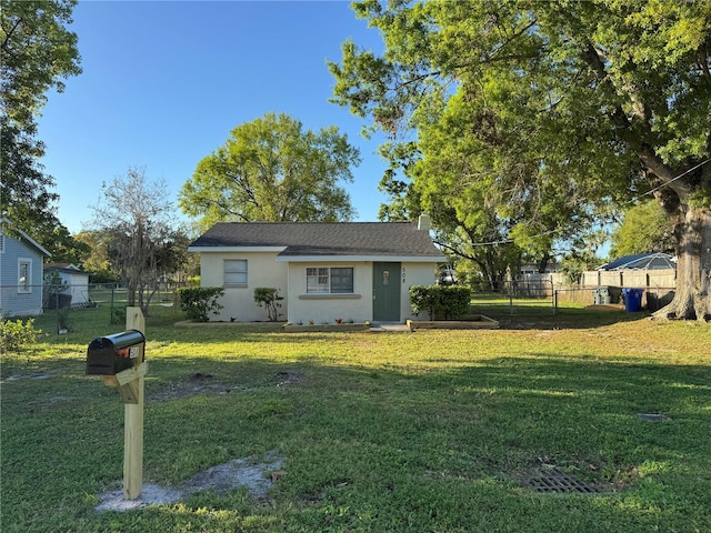 view of front facade featuring stucco siding, a front lawn, and fence