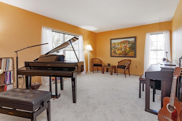 living area with baseboards and light colored carpet
