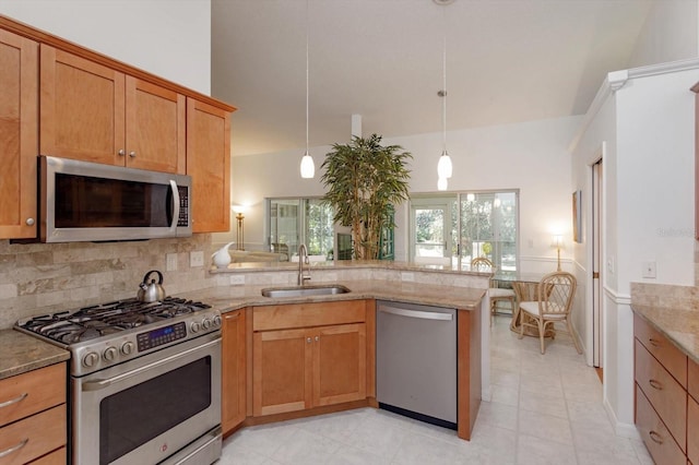 kitchen with tasteful backsplash, a sink, light stone counters, a peninsula, and stainless steel appliances