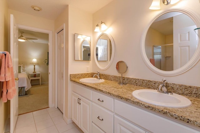 bathroom with double vanity, a ceiling fan, a sink, and tile patterned flooring