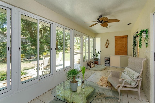 sunroom with tile patterned flooring, a ceiling fan, and a wealth of natural light