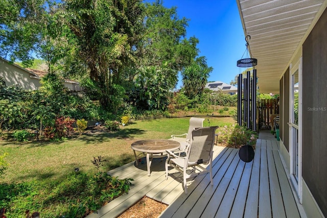 wooden terrace with a lawn and fence