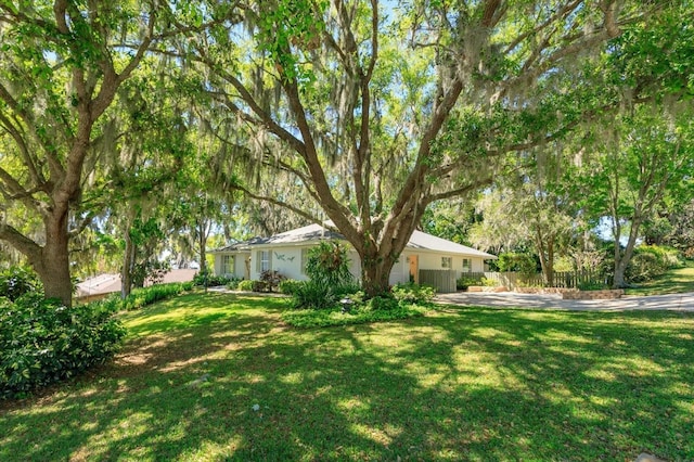 view of yard with fence and driveway