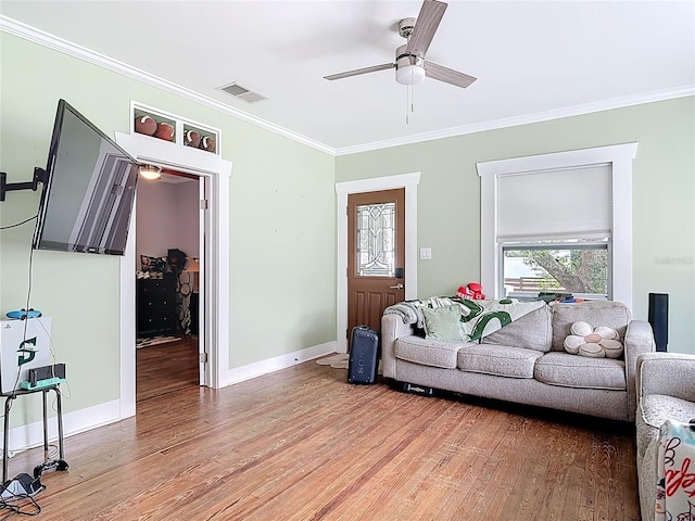 living area with visible vents, baseboards, ornamental molding, and light wood finished floors