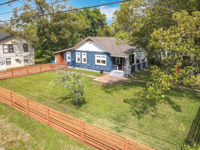 view of front of house featuring a front lawn, fence, and roof with shingles