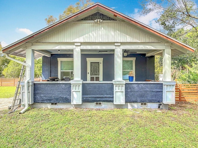 view of front facade with crawl space, a porch, a front yard, and fence