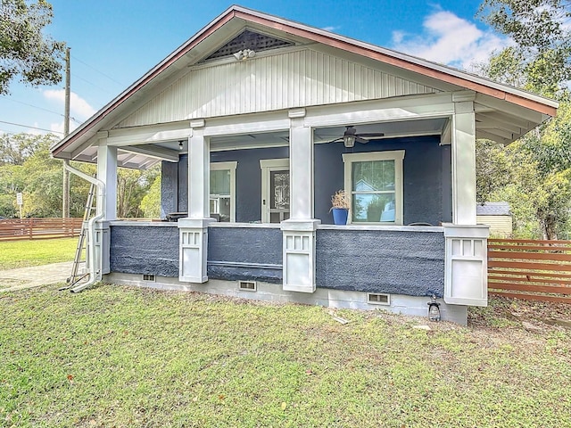 view of front of house featuring crawl space, a porch, a front lawn, and fence