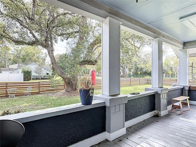 deck featuring covered porch and fence