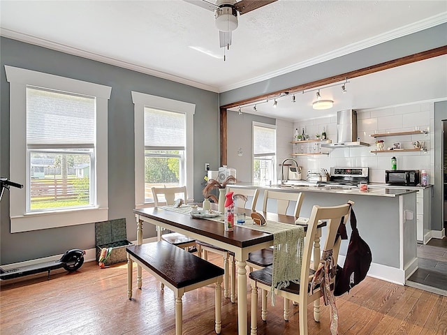 dining area with a textured ceiling, hardwood / wood-style floors, and crown molding