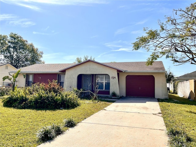 single story home with stucco siding, a front yard, concrete driveway, and an attached garage