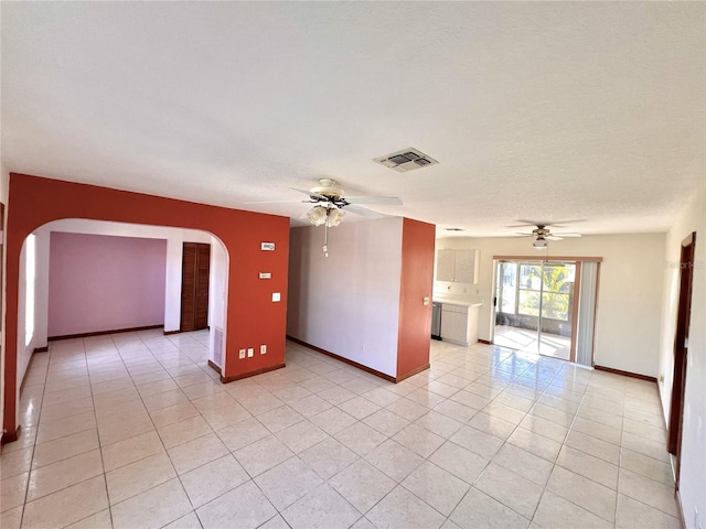 spare room with arched walkways, visible vents, a ceiling fan, and light tile patterned floors