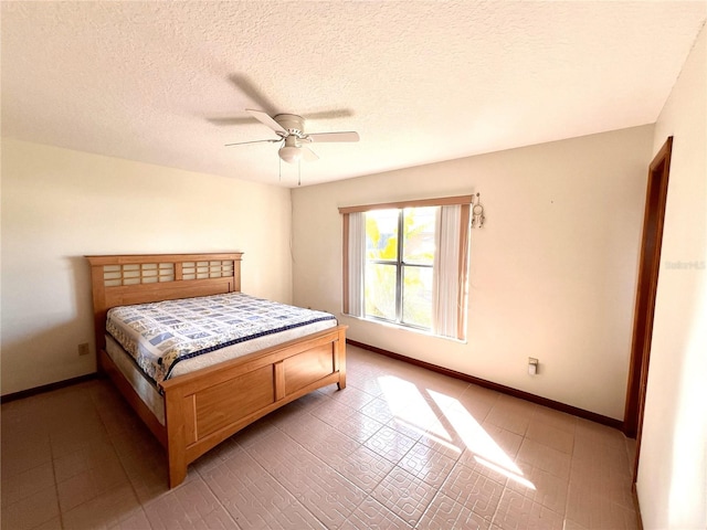 bedroom with ceiling fan, a textured ceiling, and baseboards