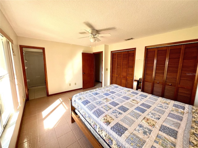 bedroom with visible vents, multiple closets, a ceiling fan, a textured ceiling, and baseboards