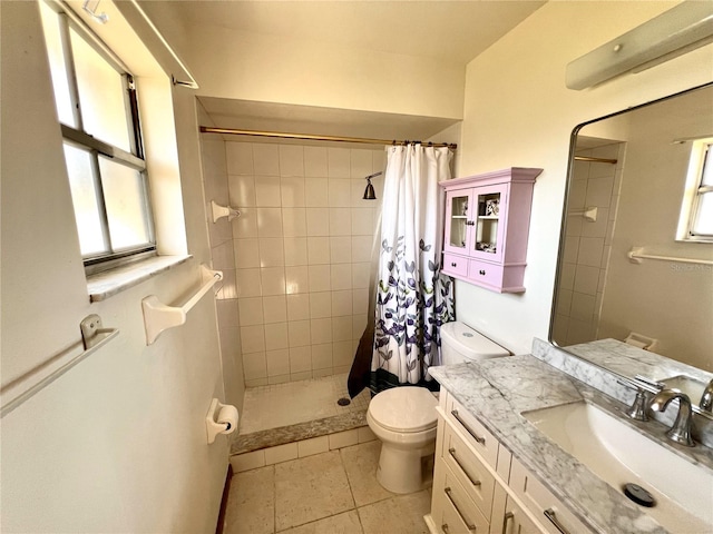 full bath featuring a tile shower, toilet, vanity, and a wealth of natural light