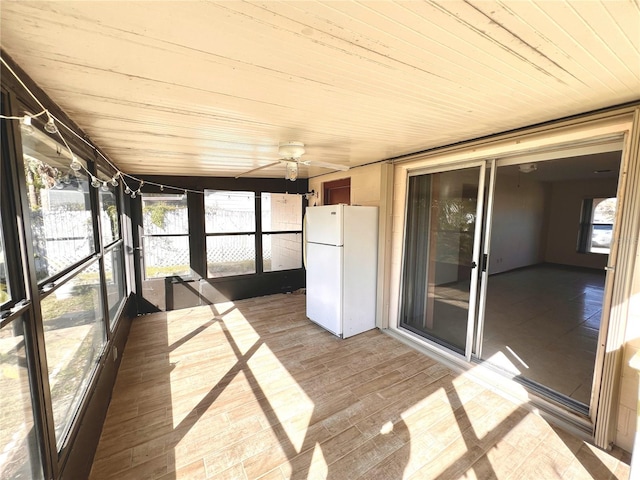 unfurnished sunroom with wood ceiling and ceiling fan