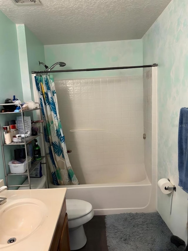 full bath with shower / bath combo with shower curtain, a textured ceiling, and toilet