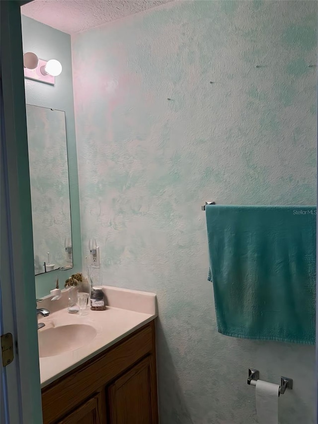 bathroom featuring vanity and a textured wall