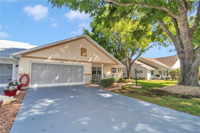 8787 SW 90th Ln Unit E, Ocala, FL 34481 - view of front facade featuring a porch, concrete driveway, a garage, and stone siding