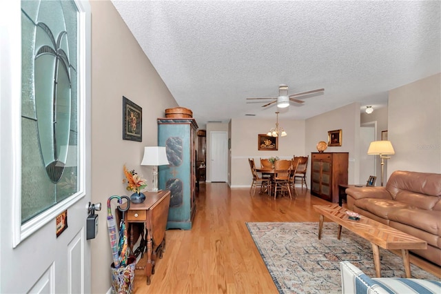 8787 SW 90th Ln Unit E, Ocala, FL 34481 - living area featuring light wood finished floors, a textured ceiling, and ceiling fan