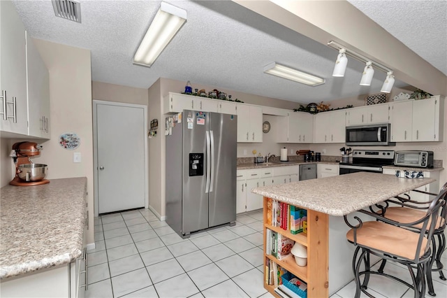 8787 SW 90th Ln Unit E, Ocala, FL 34481 - kitchen with white cabinets, appliances with stainless steel finishes, light countertops, and visible vents